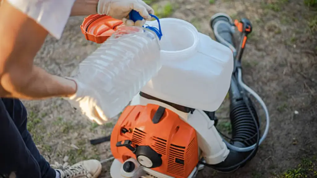 man preparing chemicals into backpack sprayer tank
