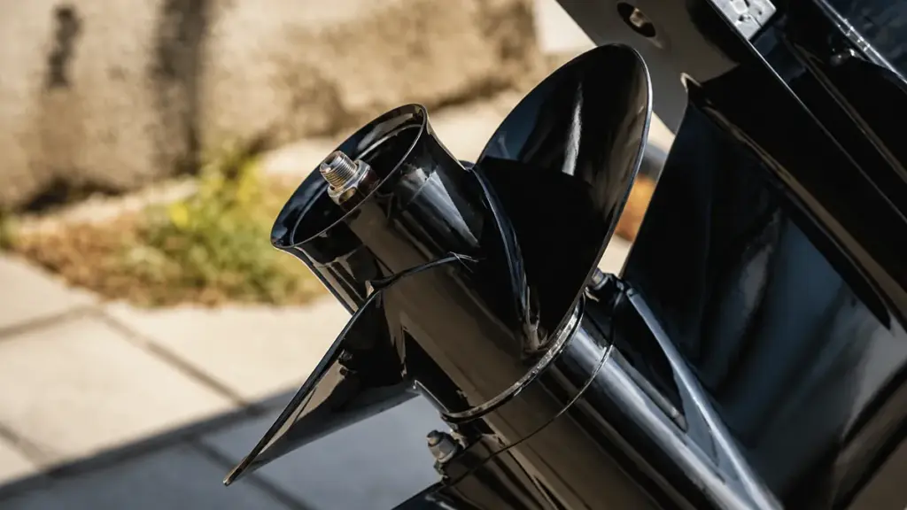 Black outboard propeller close-up with marine growth, outdoor setting