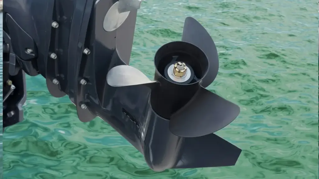 Close-up of boat outboard lower unit with propeller over clear water