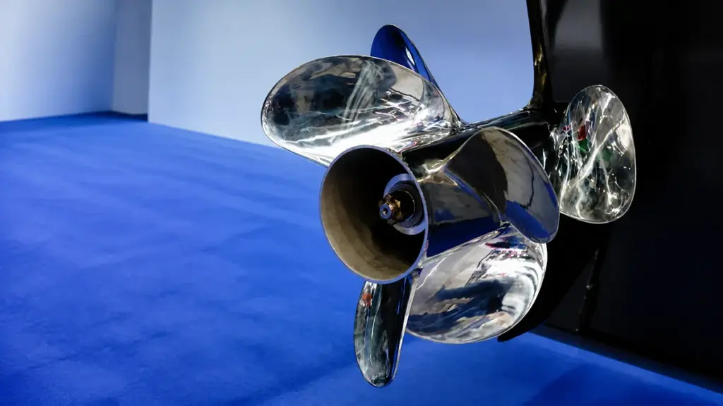 Polished metal propeller mounted on black outboard motor at exhibition