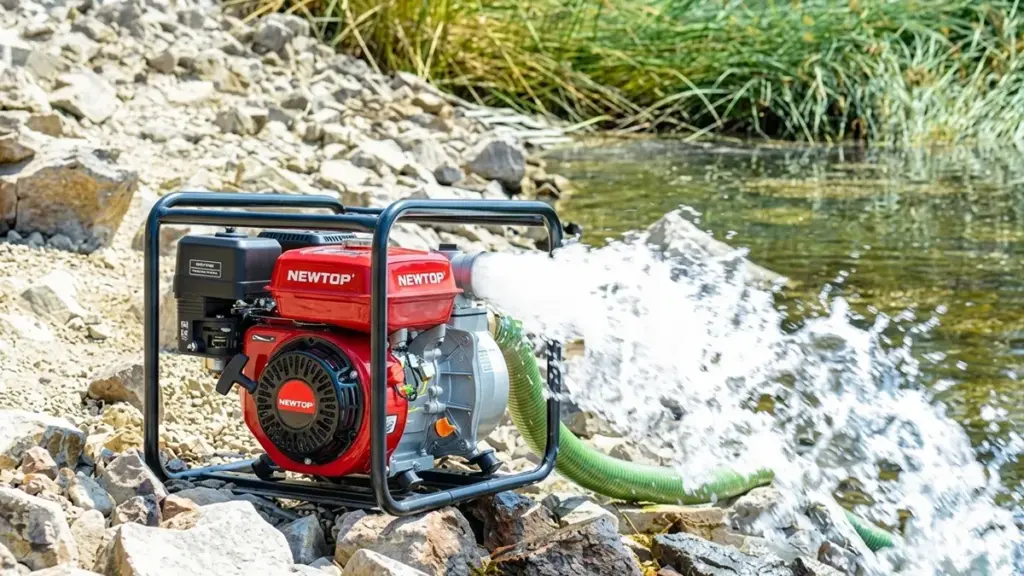 Portable red gasoline water pump is actively pumping river water