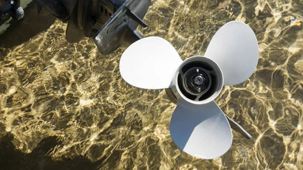 White three-blade propeller in clear shallow water, sunlit ripples