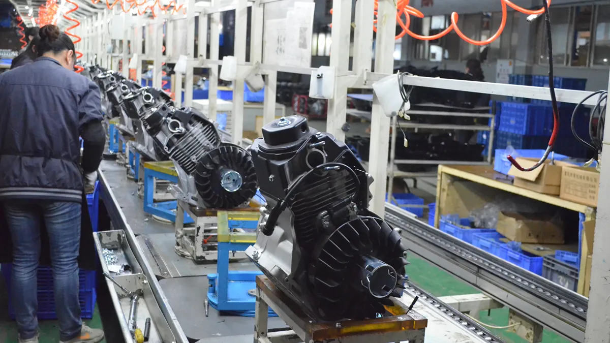 Factory worker assembling small engines along a conveyor belt production line