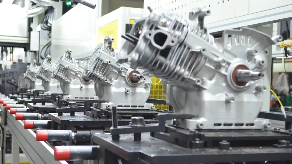 Small engine blocks lined up on a modern assembly track
