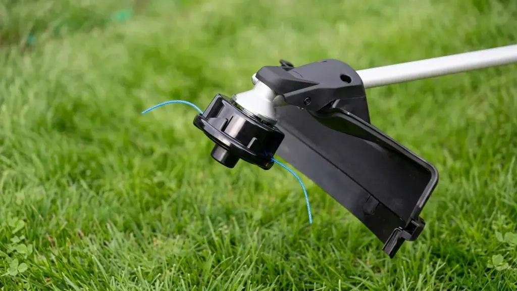 string trimmer head with blue line over grass