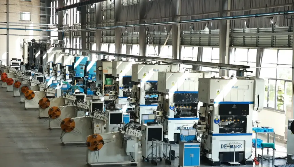 Interior of a stamping workshop featuring rows of large mechanical press machines and metal coiling systems.